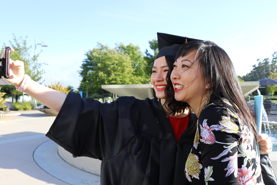 My daughter's high school graduation with photos of the ceremony — Class of 2019 plus her journey from homeschool to high college program; female student taking selfie with her mother